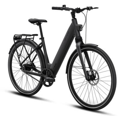 Bicicletă electrică pliabilă pentru navetă mixtă când o poți combina cu mașina sau transportul public 3
O bicicletă electrică pliabilă poate rezolva partea dificilă a unei navete care nu poate fi parcursă convenabil cu un singur mijloc de transport, poate acoperi distanța dintre casă și o stație, dintre parcare și birou sau ultima parte a drumului după coborârea din tren.
Înainte de alegere, împărțiți naveta în segmente. Notați kilometrii parcurși pe bicicletă, timpul petrecut în mașină ori în transportul public și distanța pe care trebuie să o parcurgeți cu vehiculul pliat. O bicicletă de 22 kg poate fi ușor de rulat, dar dificil de urcat zilnic pe scări. În plus, plierea nu transformă automat vehiculul într-un bagaj comod, care poate fi dus în spate ca pe un rucsac.
Combinația cu mașina
Pentru o navetă de tip parcare plus bicicletă, măsurați portbagajul în trei direcții: lățime, adâncime și înălțimea deschiderii portbagajului. De asemenea, măsurați înălțimea de încărcare. Nu-i totuna că aveți de ridicat de la sol 25 de kilograme pentru 50 de centimetri sau un metru și jumătate. Comparați aceste valori cu dimensiunile bicicletei pliate, nu cu cele ale cadrului deschis. Verificați dacă trebuie coborâtă șaua, pliate pedalele sau rotit ghidonul. O husă poate proteja tapițeria, iar punctele de fixare împiedică deplasarea bicicletei la frânare.
Greutatea contează la fiecare încărcare și descărcare. Simulați mișcarea cu un obiect de masă apropiată înainte de cumpărare, mai ales dacă marginea portbagajului este înaltă. Bateria detașabilă poate reduce greutatea ridicată cu câteva kilograme, însă trebuie transportată și protejată separat. Nu lăsați acumulatorul într-o mașină care se poate încălzi sau răci excesiv.
Calculați și distanța parcursă efectiv pe două roți. Dacă lăsați mașina la 6 km de birou, bicicleta trebuie să acopere 12 km pe zi. La un consum orientativ de 10–15 Wh/km, necesarul ar fi de aproximativ 120–180 Wh. Adăugați o rezervă pentru vânt, ocoliri și temperaturi scăzute, fără să considerați calculul o autonomie garantată.Combinația cu transportul public
Regulile de acces diferă între operatori, tipuri de vehicule și intervale orare. Unele servicii tratează bicicleta pliată și ambalată ca bagaj, în timp ce altele impun restricții de dimensiune, spațiu sau oră. Verificați regulamentul operatorului înainte de fiecare traseu nou și nu presupuneți că accesul acceptat într-un tren este permis automat într-un autobuz aglomerat.
Exersați plierea acasă și cronometrați procesul. Dacă sunt necesare cinci minute și mai multe operațiuni, o legătură cu timp scurt poate deveni stresantă. Bicicleta pliată trebuie să rămână stabilă, iar elementele murdare sau mobile nu trebuie să îi incomodeze pe ceilalți călători. O curea de transport și o husă pot fi utile, dar adaugă greutate și trebuie depozitate în timpul mersului.
Roțile mai mici ajută de regulă la obținerea unui pachet compact, însă pot reacționa mai neplăcut la gropi și denivelări. Verificați confortul pe porțiunea pe care veți pedala, nu numai ușurința depozitării. Poziția pe bicicletă, reglajul șeii și frânele rămân importante chiar dacă segmentul parcurs are doar câțiva kilometri.
Un test realist include întregul drum: scoaterea din locuință, plierea, ridicarea, trecerea prin porți sau turnicheți, depozitarea și încărcarea. Măsurați cel mai îngust punct și păstrați câțiva centimetri de rezervă. Dacă bicicleta trebuie ținută sub birou, verificați spațiul cu obiectele deja existente, nu într-o zonă goală.Luați în calcul și situația în care unul dintre segmente nu funcționează. Dacă parcarea este plină sau trenul nu permite bicicleta la ora aleasă, trebuie să puteți continua drumul ori să vă întoarceți în siguranță. O autonomie de rezervă și un antifurt potrivit oferă mai multe opțiuni. Păstrați la îndemână luminile, o cameră de rezervă sau un kit compatibil și datele traseului alternativ. Pentru naveta repetată, câteva minute economisite la pliere valorează mai mult decât o funcție pe care o folosiți rar, așa că testul practic ar trebui să cântărească mai mult decât lista de dotări.
Naveta mixtă funcționează bine atunci când bicicleta elimină așteptarea sau mersul pe jos de la capetele traseului fără să creeze o problemă nouă la transport și depozitare. Alegeți după dimensiunile pliate, greutatea pe care o puteți ridica, energia necesară zilnic și regulile operatorului, iar pentru consultanță privind vehiculele electrice și informații despre garanția de 7 ani acordată acumulatorilor triciclurilor și scuterelor electrice puteți apela la Voltarom.